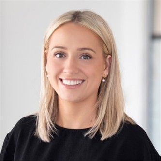Anoushka Chandler in a black top, in front of a grey background
