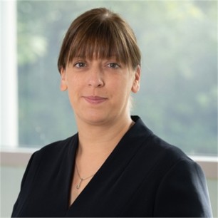 Jennifer Curtis in a black jacket, in front of a window