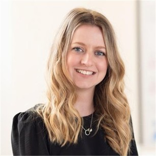 Kerry Haugh in a black top, in front of a pale background