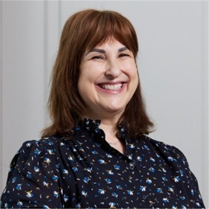 Jane Ingleby in a black floral top, in front of a grey background