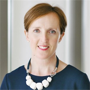 Caitlin Jenkins in a blue top, in front of a pale background